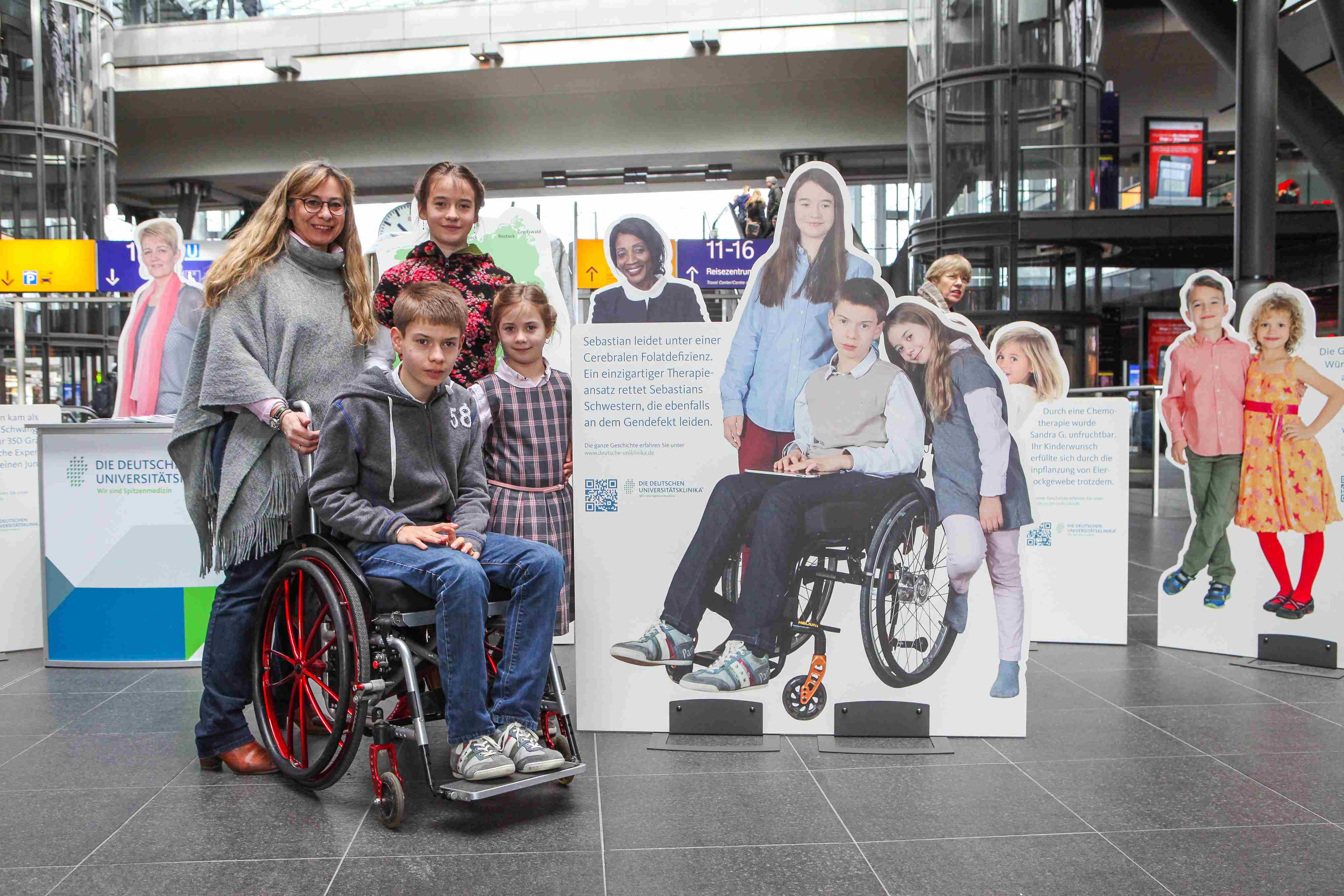 Familie Bopp vor ihrem Aufsteller im Berliner Hauptbahnhof 